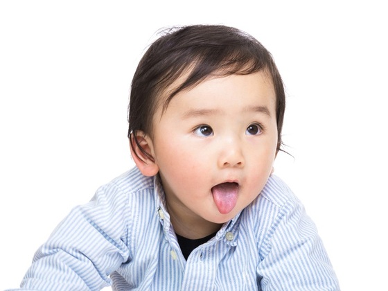 Criança mostrando a língua - Foto: leungchopan/ShutterStock.com