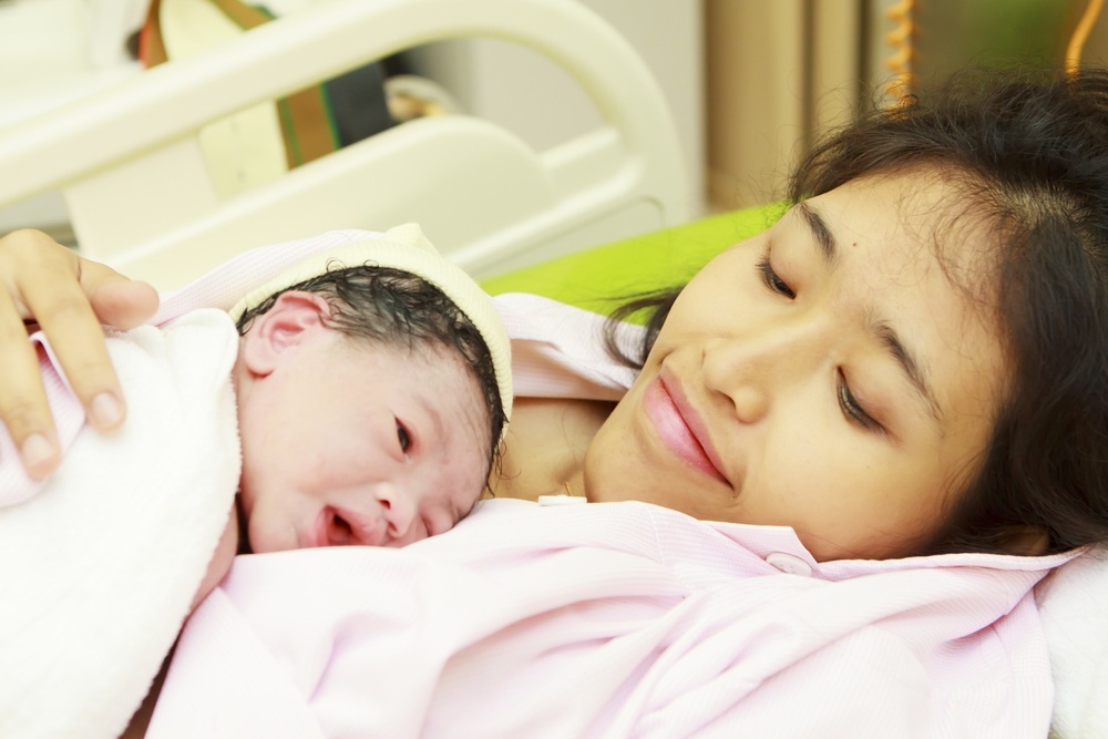 Recém-nascido deitado sobre a mãe - foto: Arief Juwono/ShutterStock.com