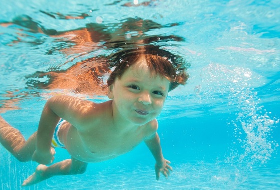 Criança submersa na água da piscina - Foto: Sergey Novikov/ShutterStock.com