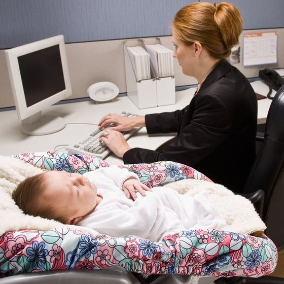 Mulher trabalhando com seu bebê ao lado - AVAVA / ShutterStock