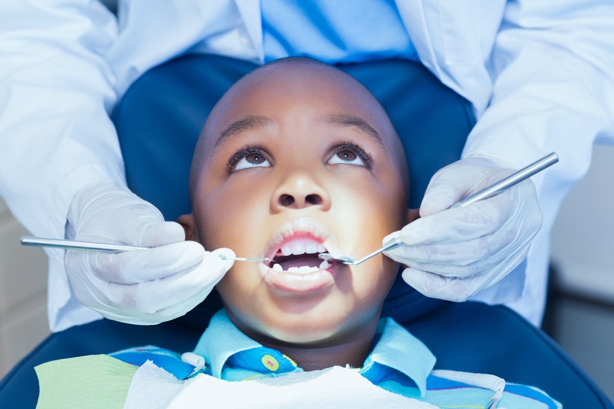 Criança no consultório do dentista tendo seus dentes examinados - foto: wavebreakmedia/ShutterStock.com Criança no consultório do dentista tendo seus dentes examinados - foto: wavebreakmedia/ShutterStock.com